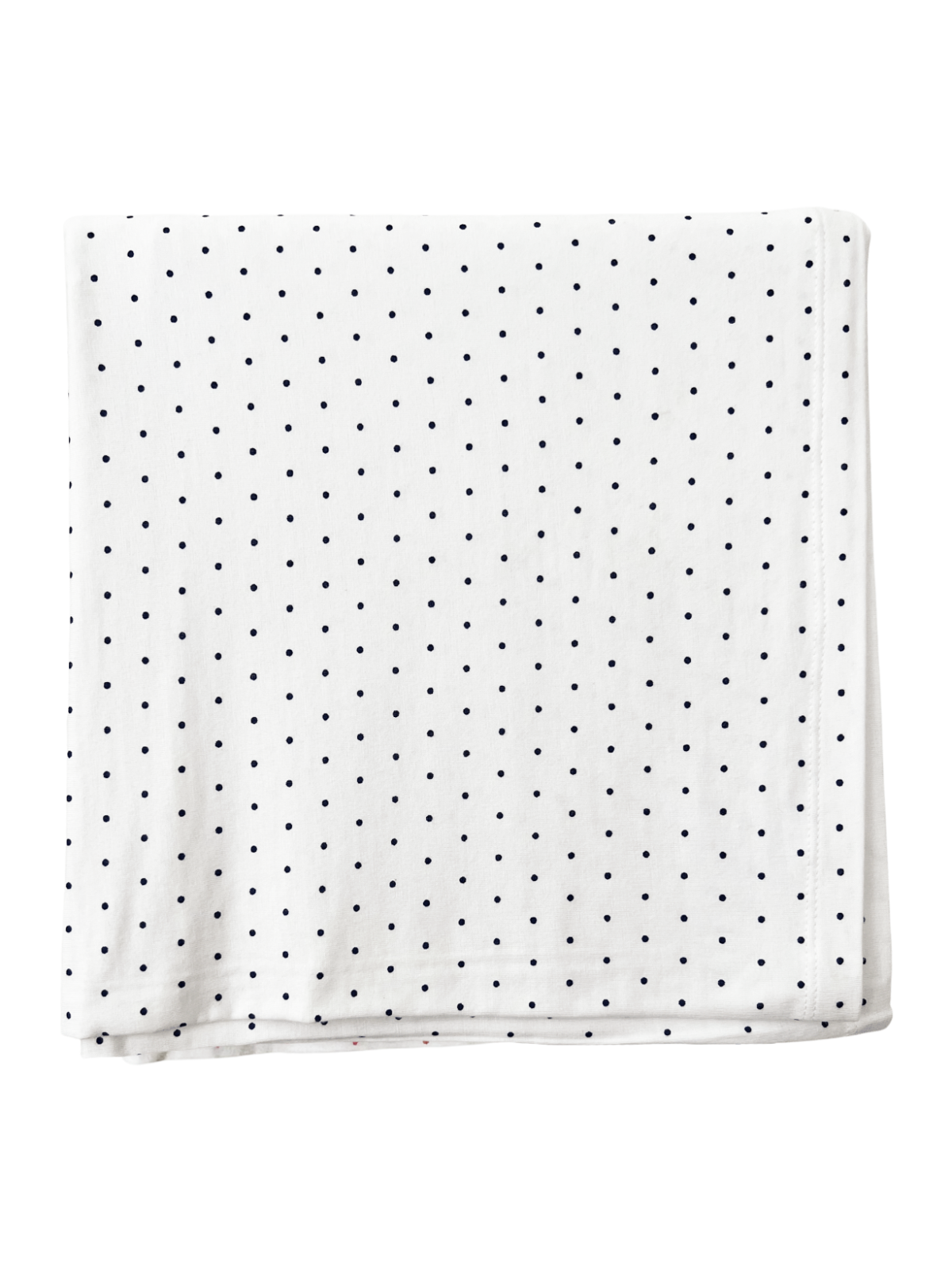 White blanket with a navy polka dot pattern, folded neatly on a flat surface.