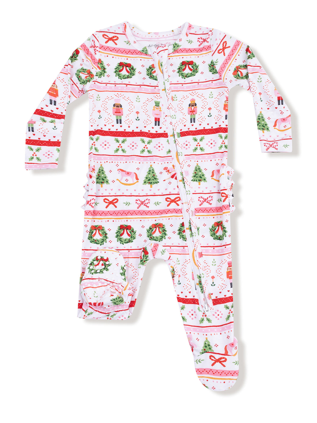 Festive holiday children's onesie with nutcracker, wreath, and Christmas tree patterns. Light pink background.