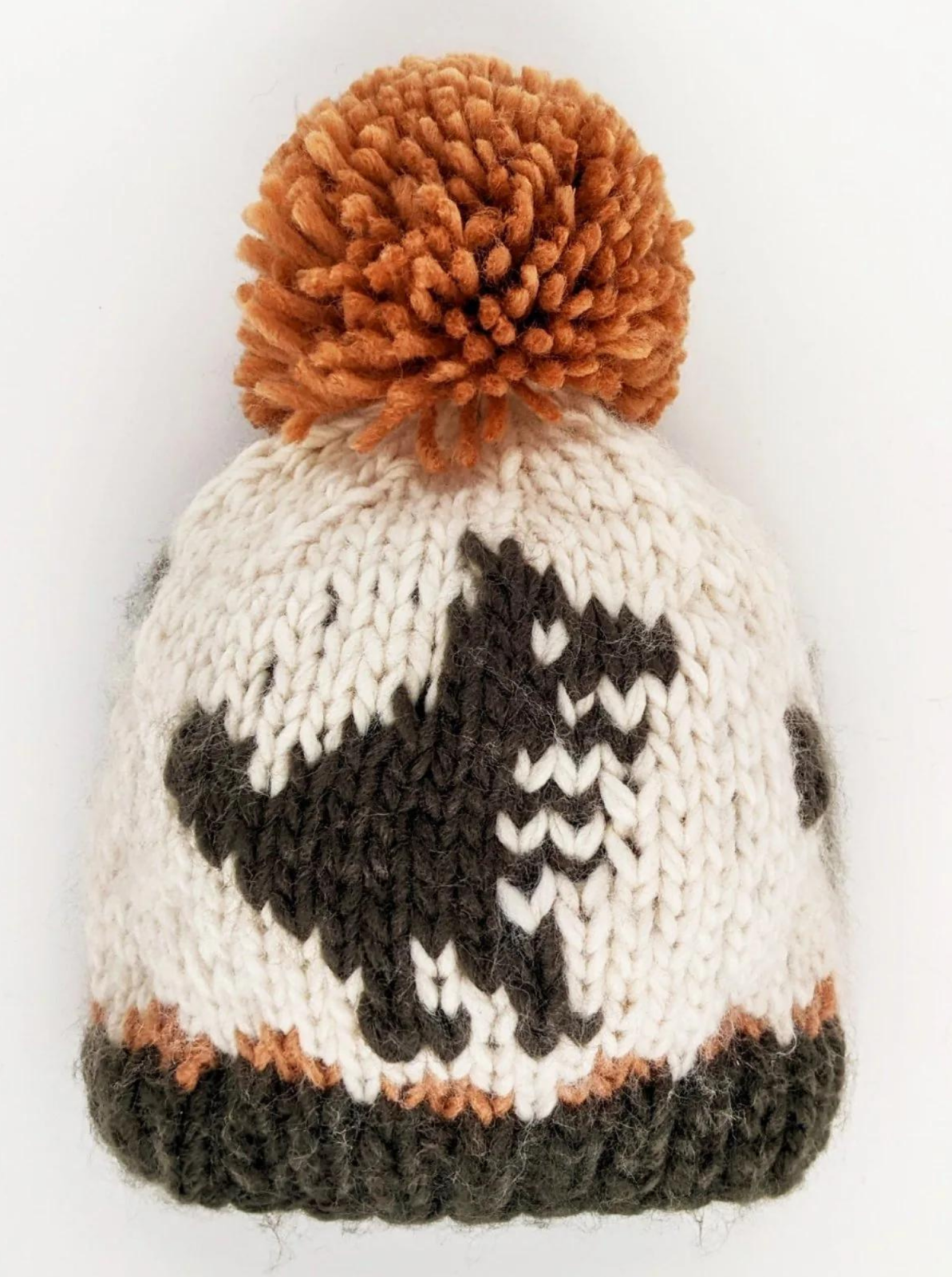 Knitted beanie hat with a pom-pom, featuring a dinosaur design in cream, brown, and black colors.