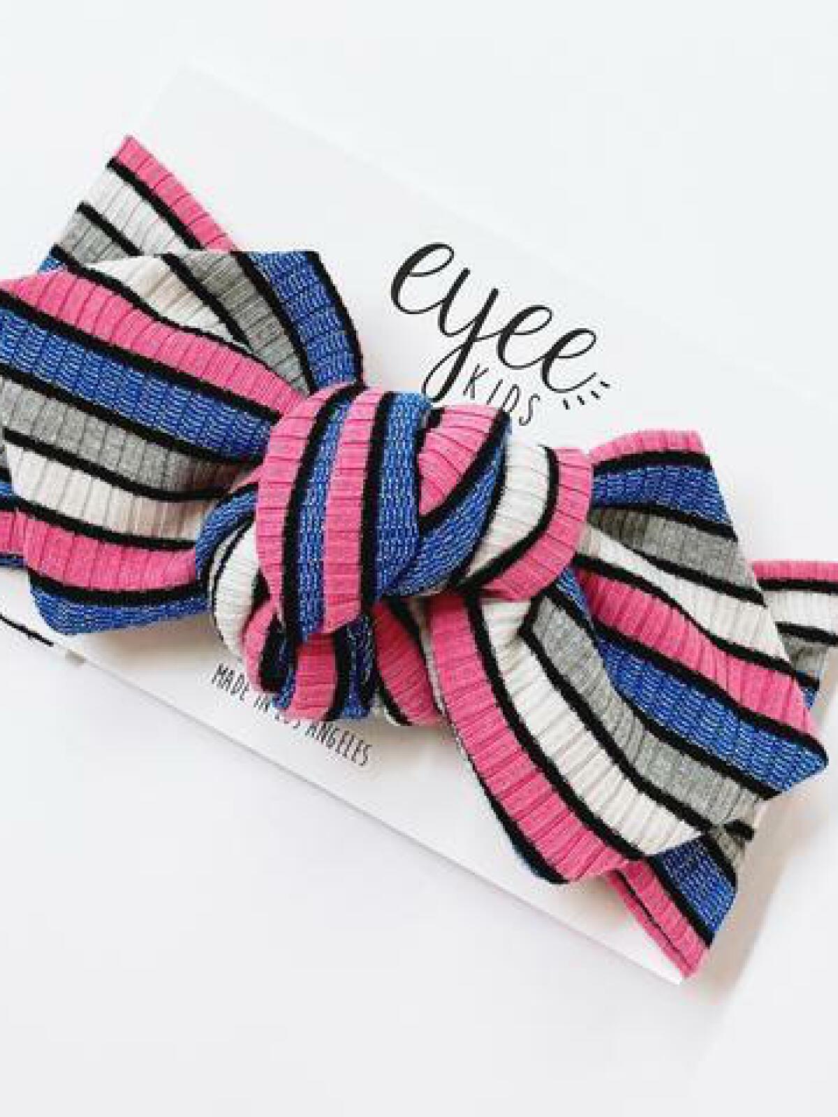 Colorful striped headband in pink, blue, gray, and black, displayed on an Eyyee Kids card.