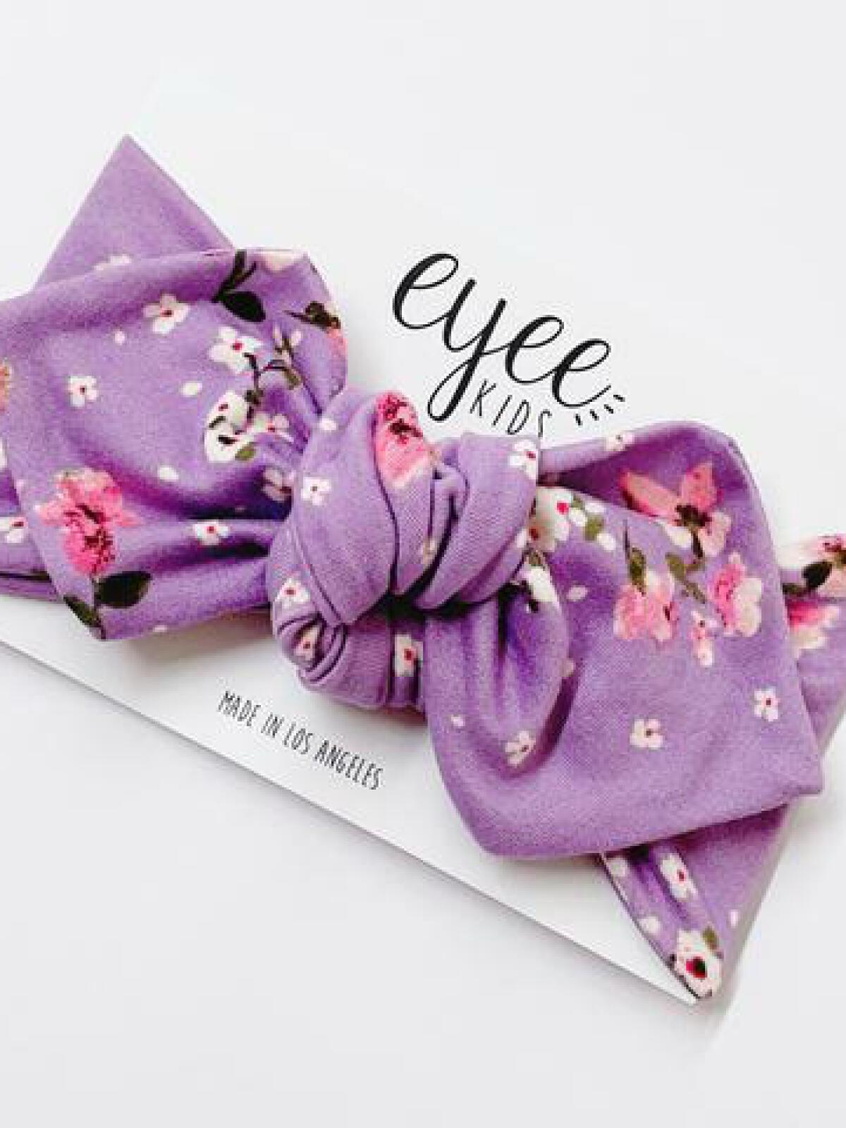 Purple floral kids' headband on a card, labeled "eyeee kids," made in Los Angeles.