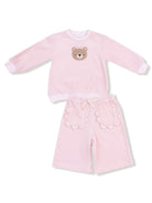 Pink children's outfit featuring a bear design on the top and scalloped pockets on the shorts.