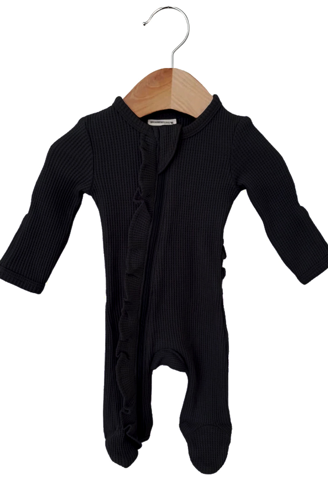 Black baby onesie with long sleeves and ruffle details, hanging on a wooden hanger against a white background.