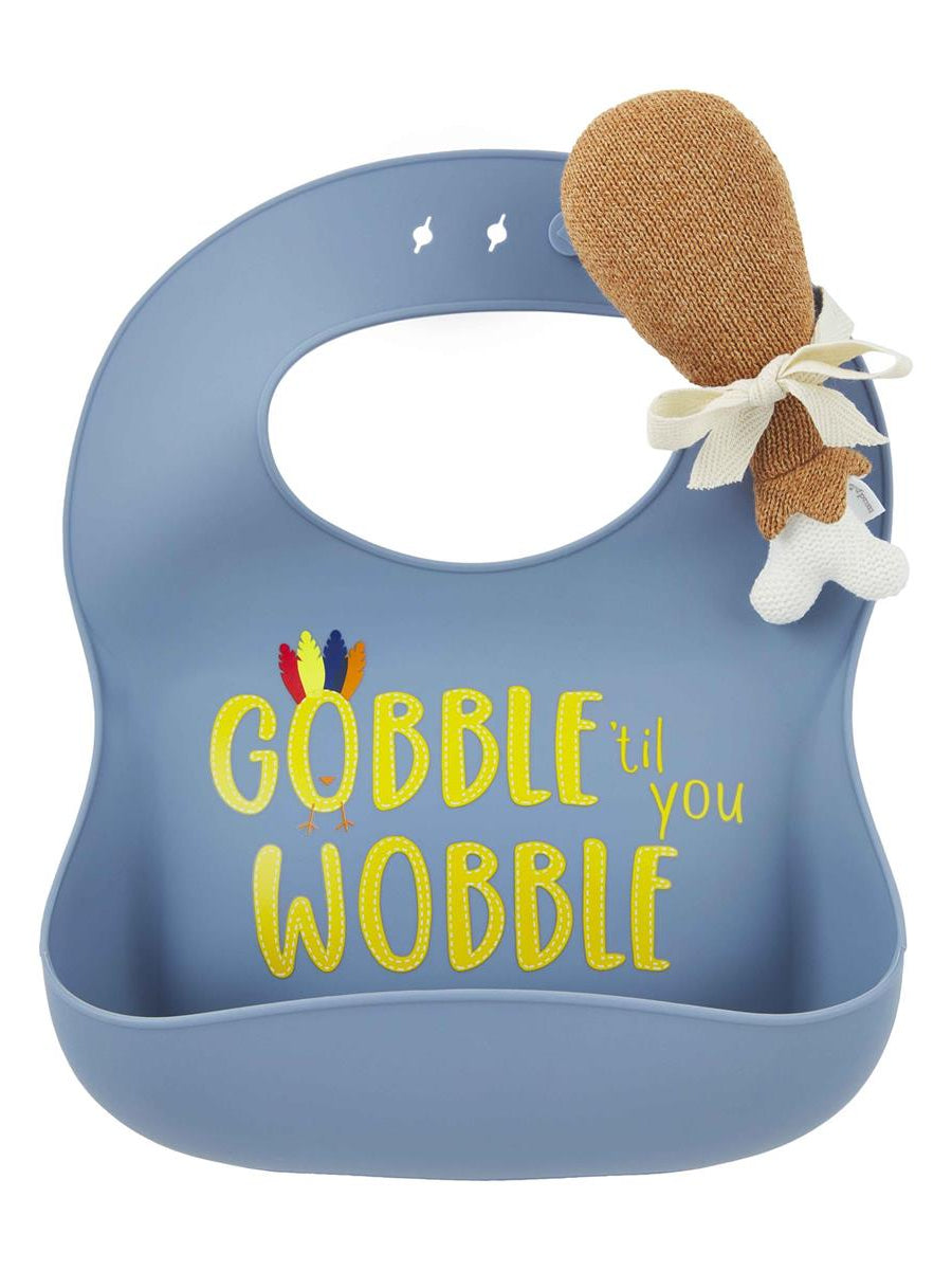Blue bib with "GOBBLE til you WOBBLE" text and a plush turkey leg attached. Ideal for mealtime fun.