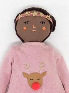 Doll with brown skin, braided hair, and a pink outfit featuring a reindeer design and a star headband.