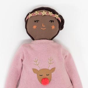 Doll with brown skin, braided hair, and a pink outfit featuring a reindeer design and a star headband.