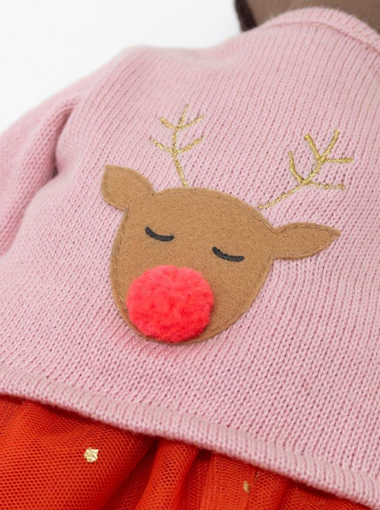 Pink sweater with a reindeer face, featuring closed eyes and a red pom-pom nose, paired with an orange skirt.