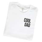 White t-shirt folded with the text "COOL DAD" in bold black letters on the front.