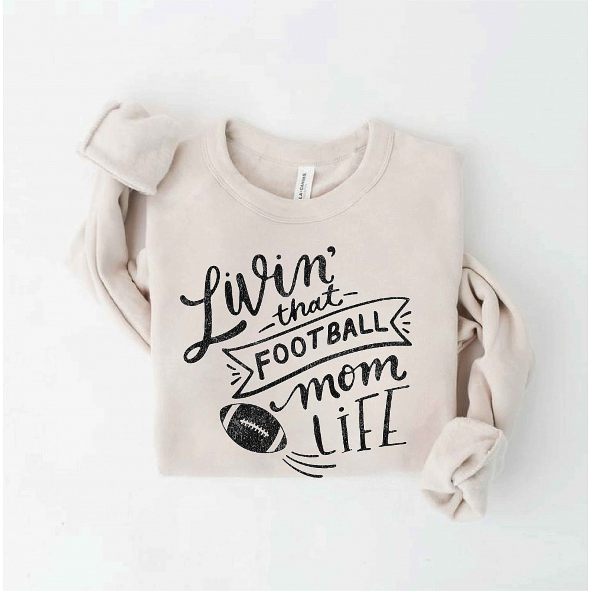 Beige sweatshirt with "Livin' that Football Mom Life" text and a football graphic. Cozy and casual design for moms.