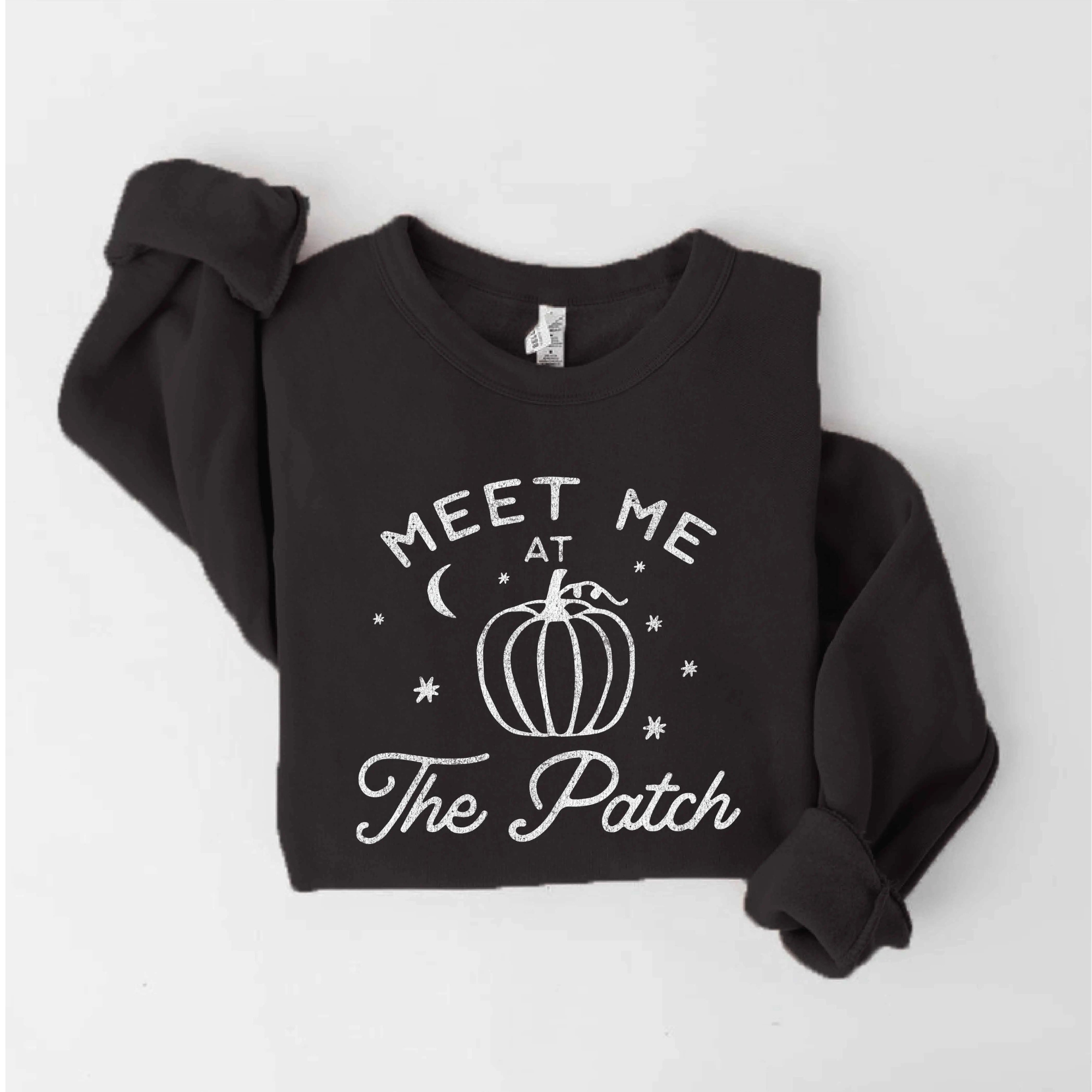 Black sweatshirt with "Meet Me at The Patch" text and pumpkin graphic. Perfect for fall gatherings.