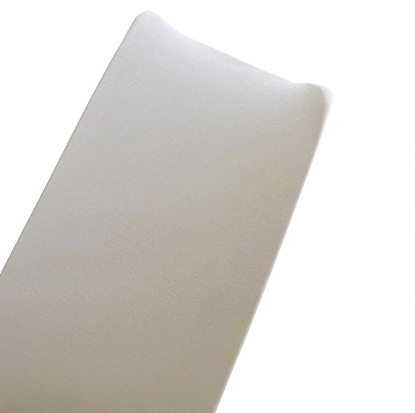 Close-up of a smooth, beige foam mattress corner on a white background.