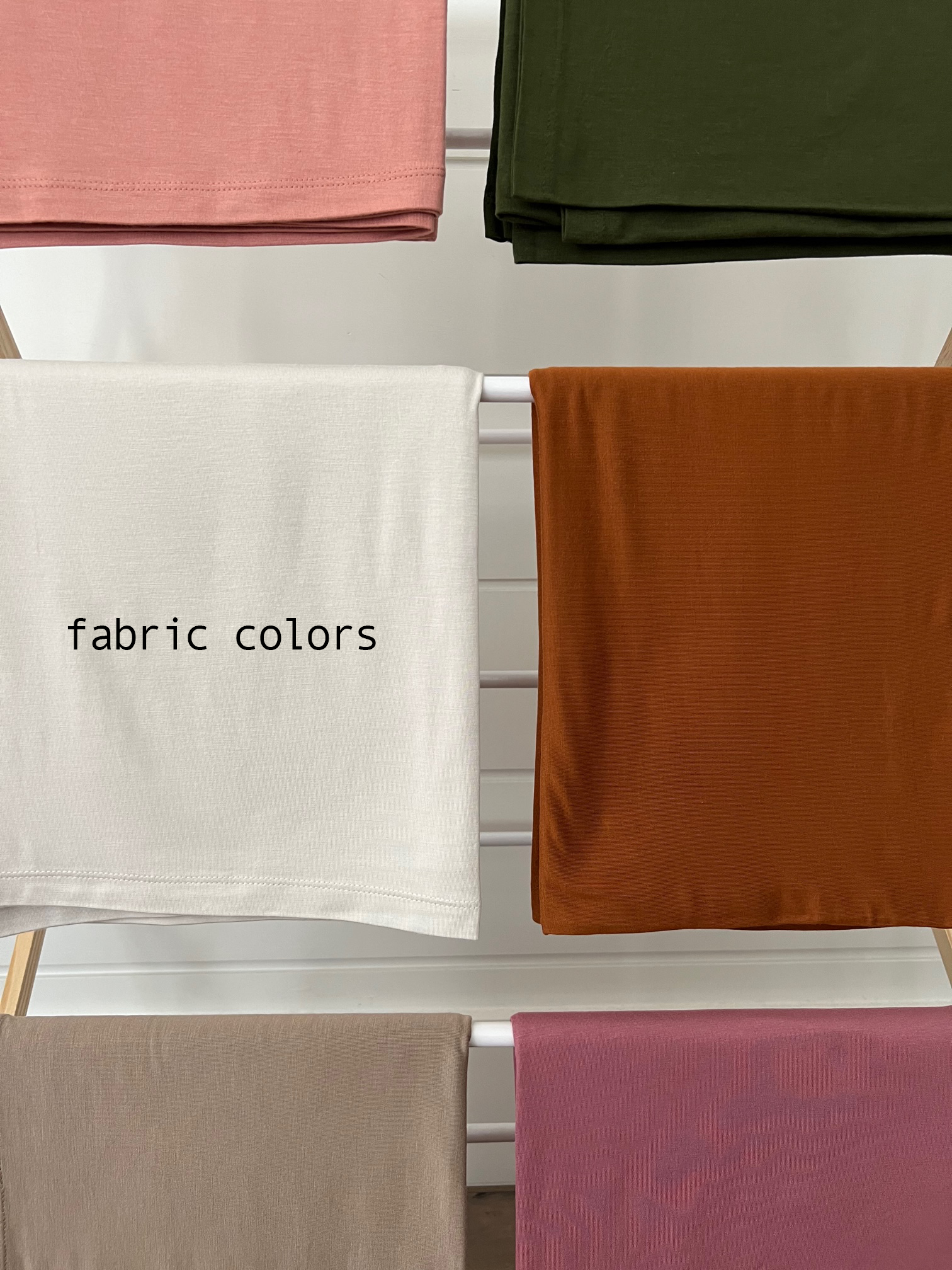 Assorted fabric swatches in various colors displayed on a rack with the text "fabric colors."