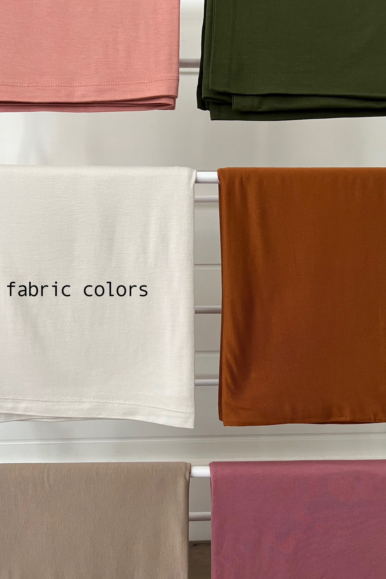 Display of various fabric colors with text "fabric colors" on a white fabric in the center.