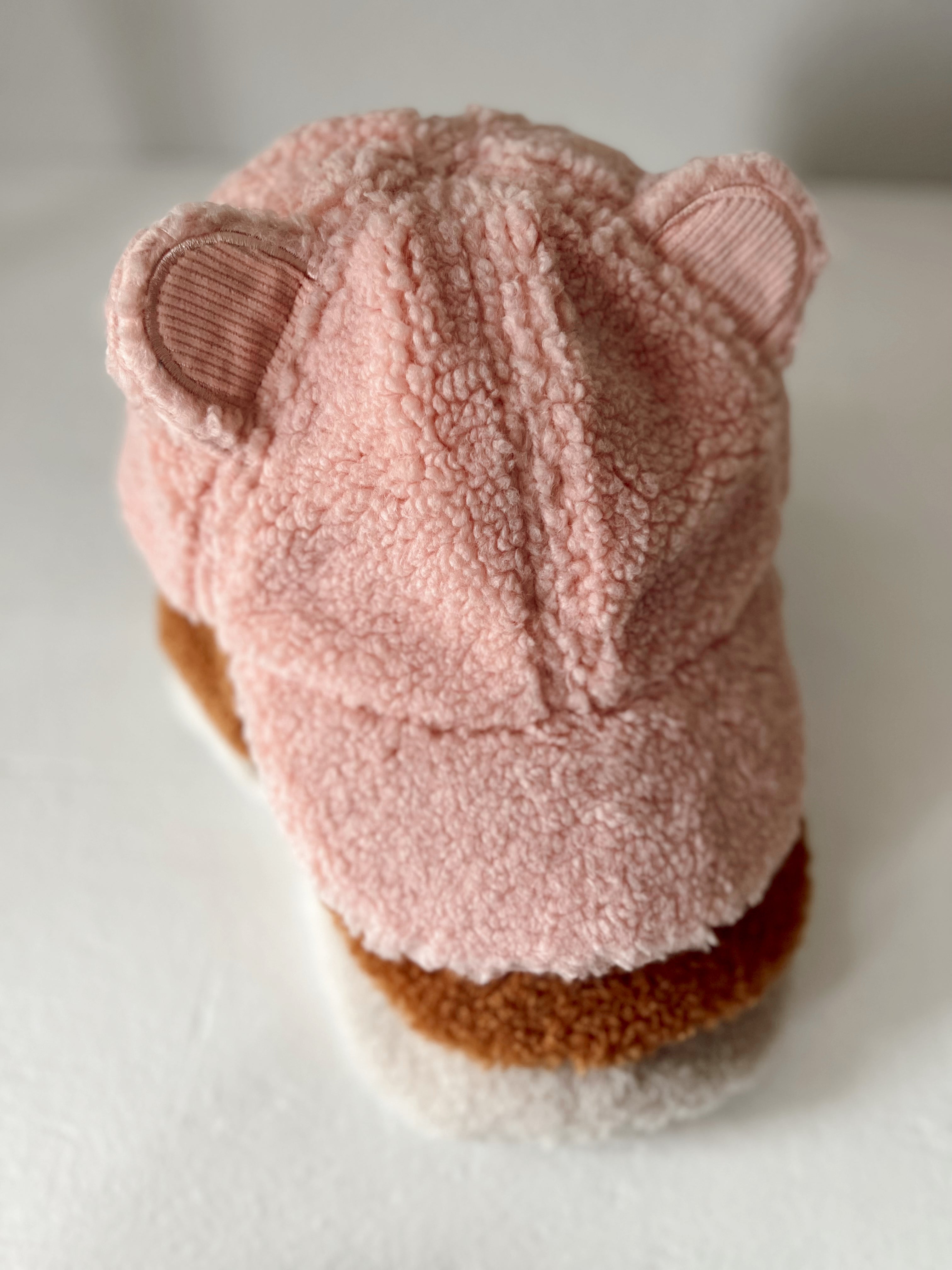 Pink fluffy cap with bear ears displayed on a white background.