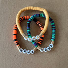 Colorful beaded bracelets with the word "MAMA" displayed on each, arranged on a brown background.