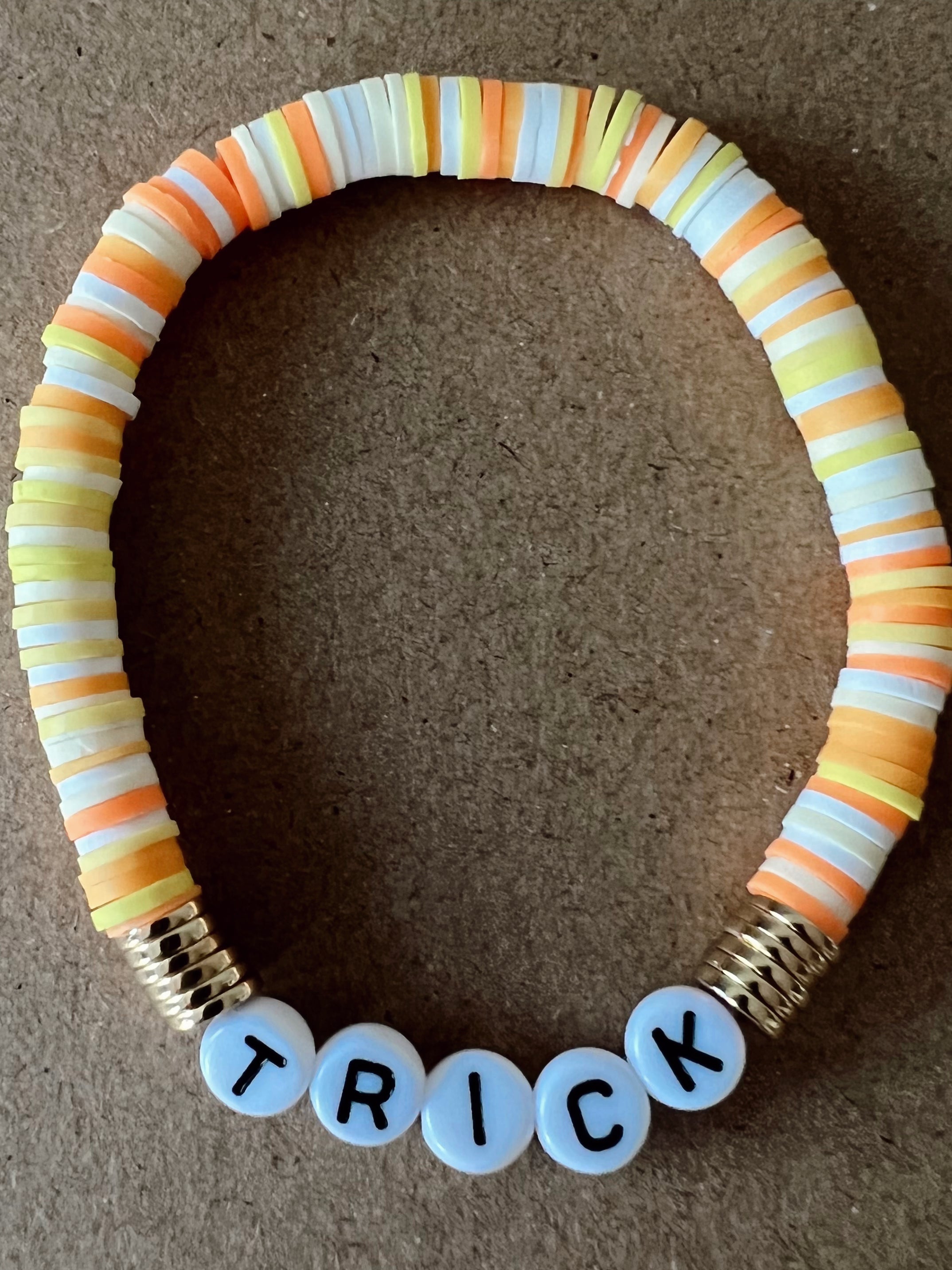 Colorful beaded bracelet with "TRICK" spelled out in white letters.