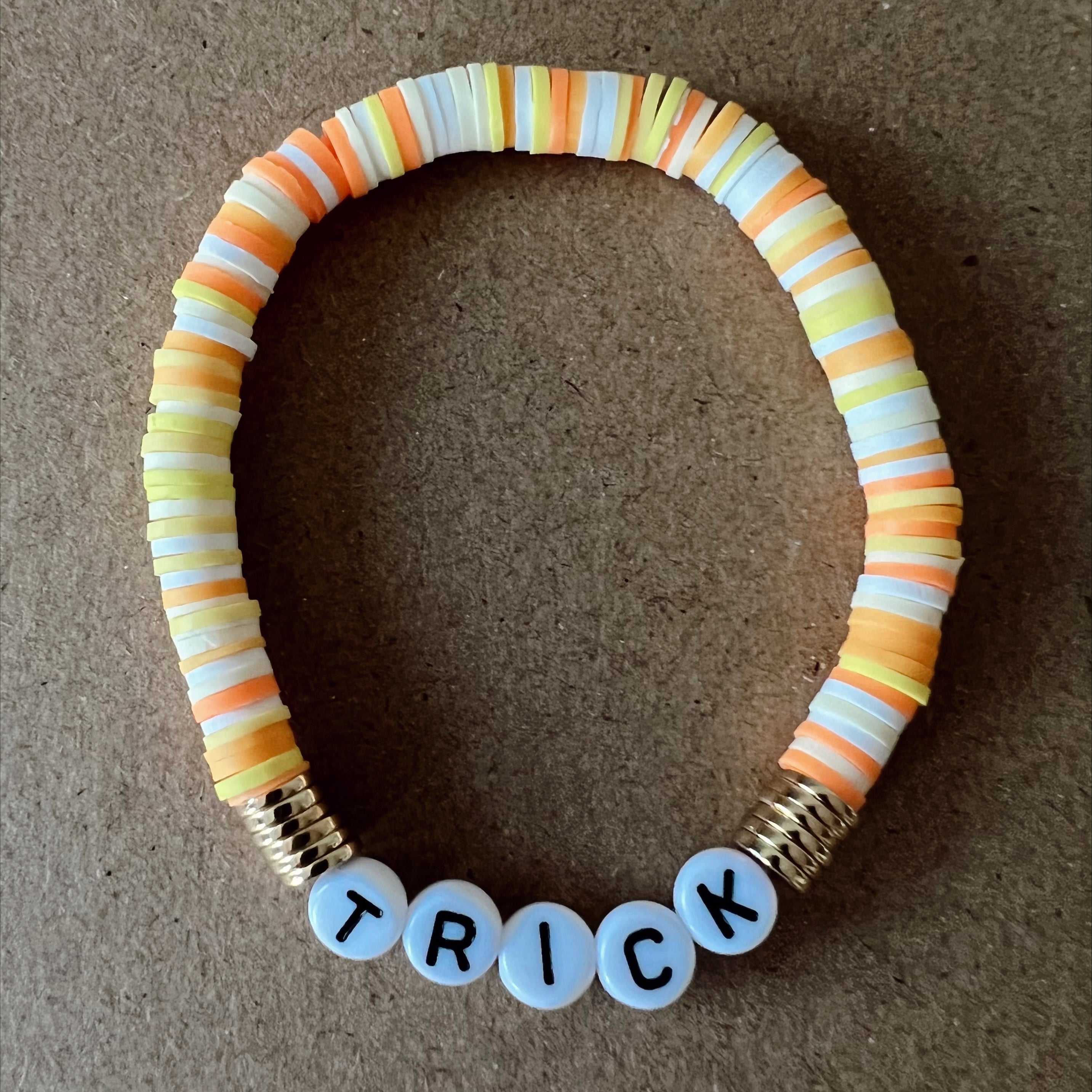 Colorful beaded bracelet with "TRICK" spelled out in white letters.