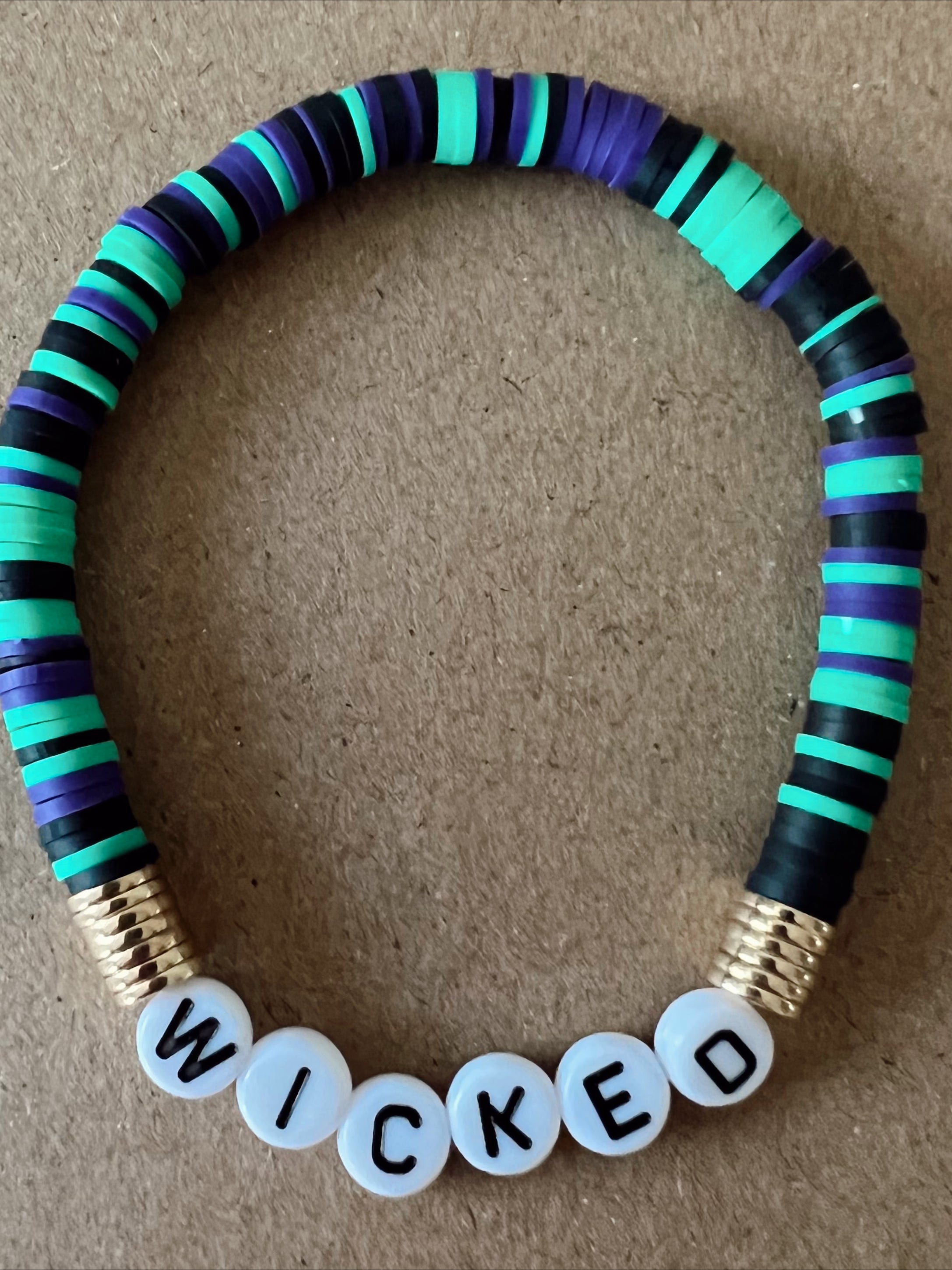 Colorful beaded bracelet with the word "WICKED" spelled out in block letters.
