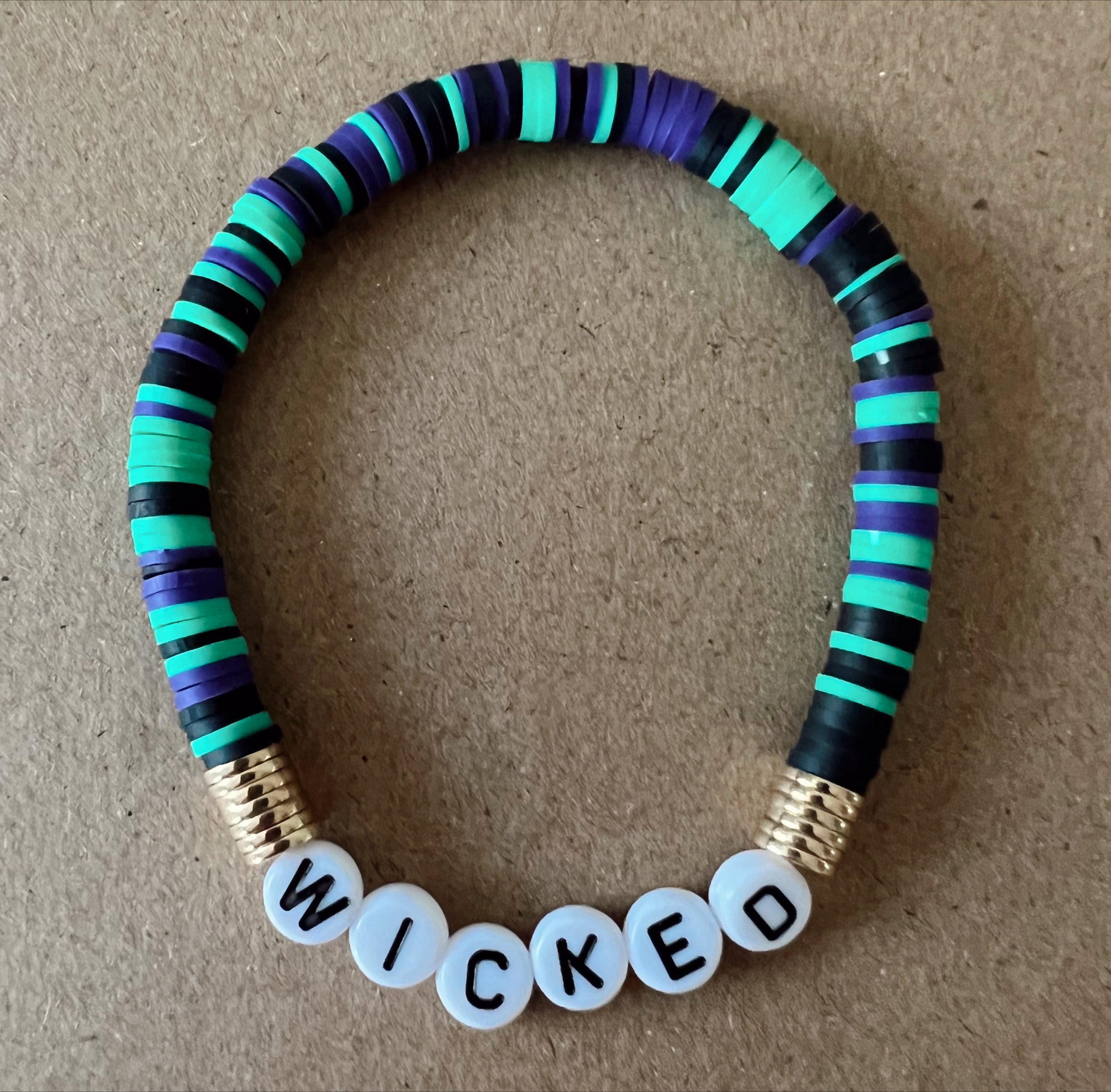 Colorful beaded bracelet with the word "WICKED" spelled out in block letters.