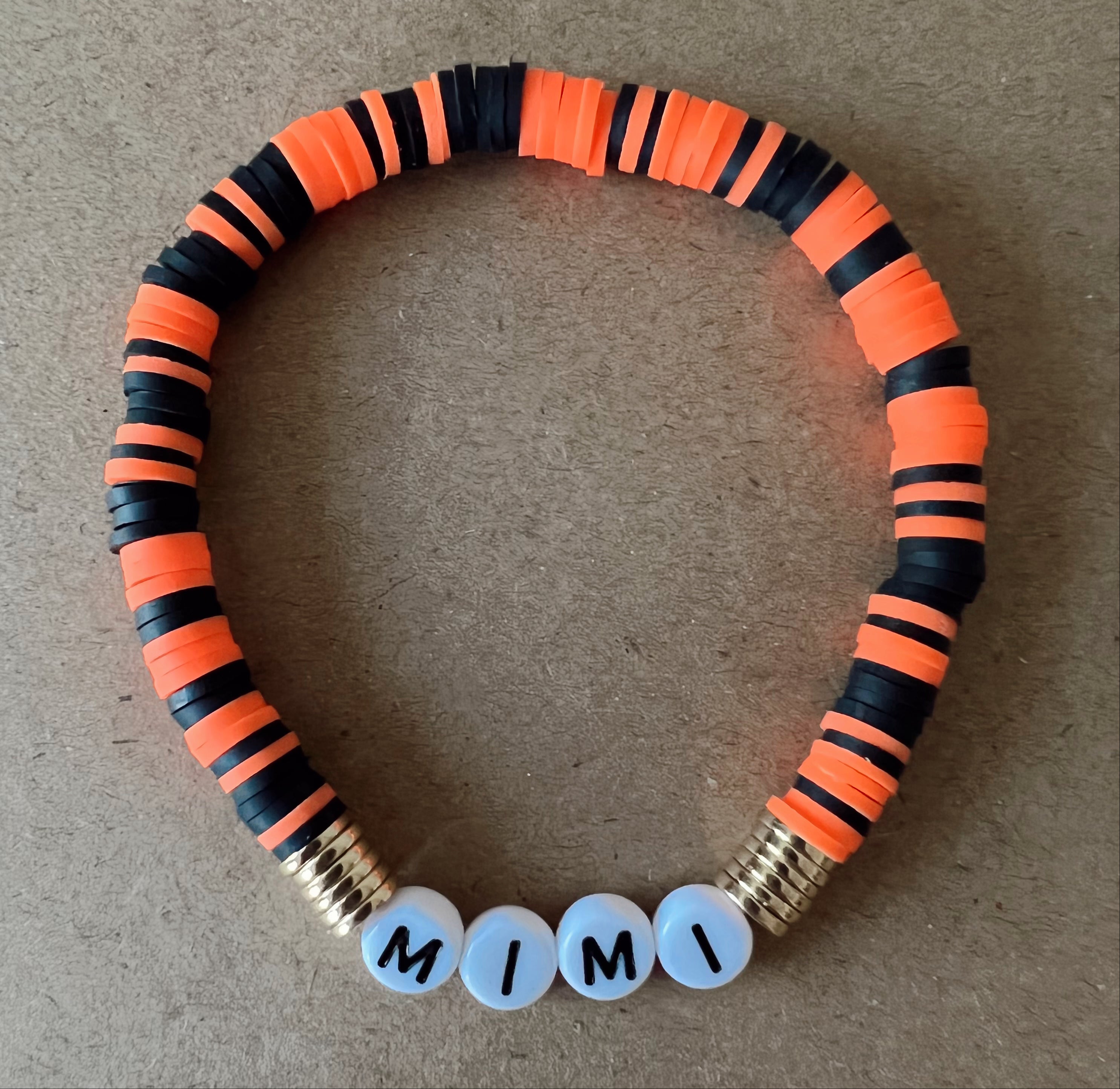 Colorful beaded necklace featuring orange and black rubber beads with letters spelling "MIMI."