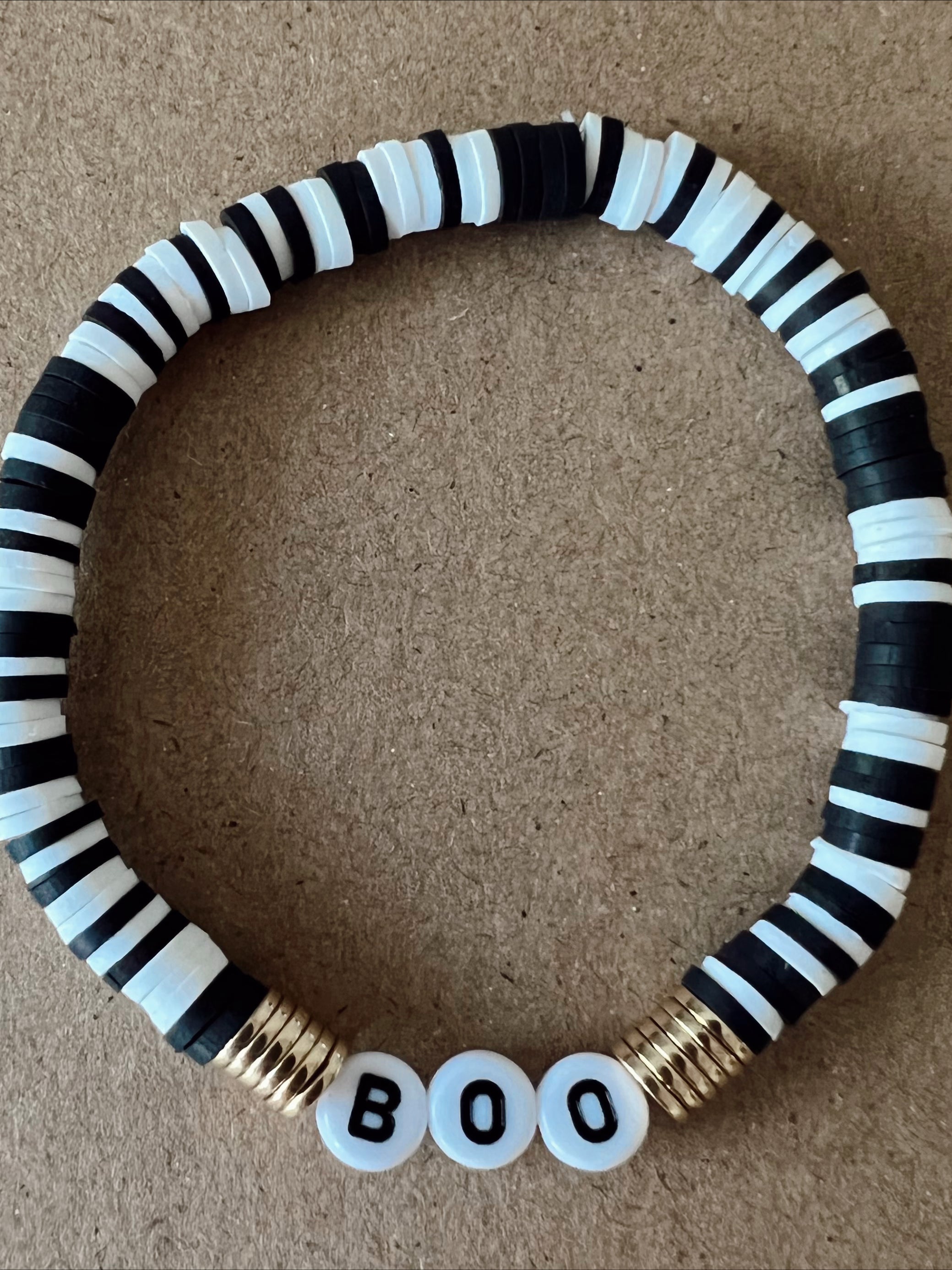 Black and white beaded bracelet with gold spacers and the word "BOO" in white beads.