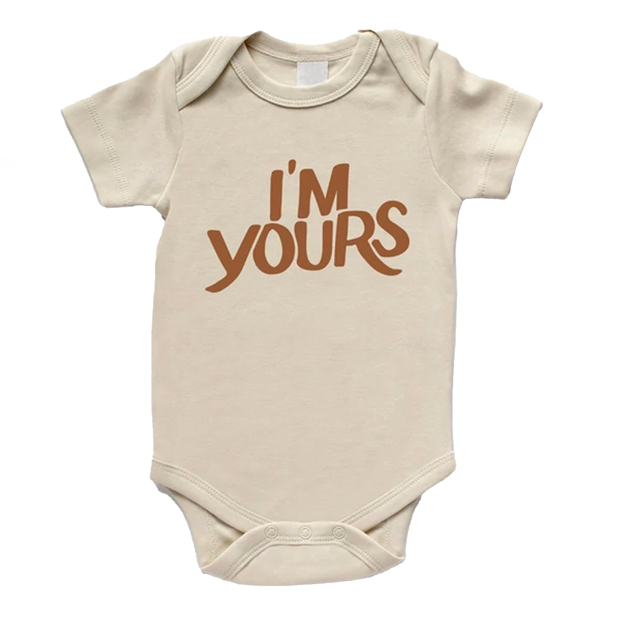 Beige baby onesie featuring "I'M YOURS" in bold brown text. Suitable for infants and toddlers.