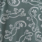 Pattern of white lizards on a teal background, featuring playful designs and various poses.