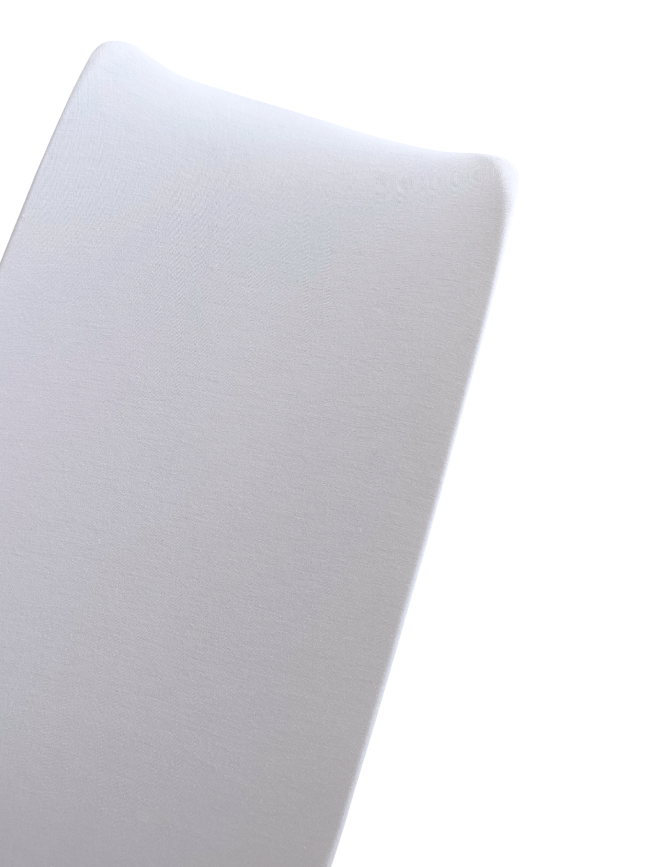 Close-up of a smooth, white surface reflecting light, suggesting a soft texture and contemporary design.