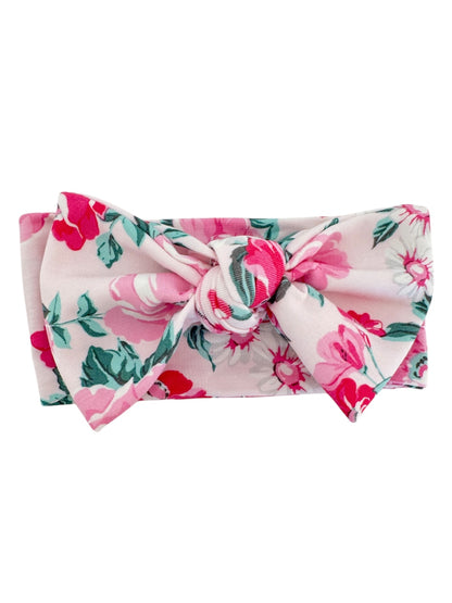 Floral headband with a large bow, featuring pink and green roses on a light background. 