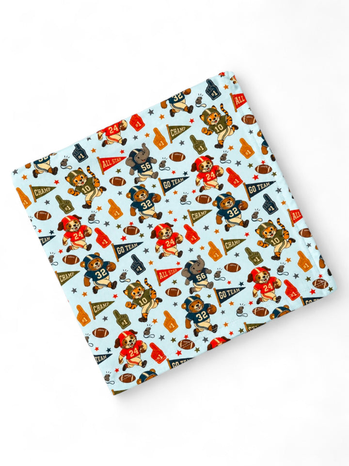 Patterned fabric featuring playful sports-themed cartoon animals and vibrant team colors. Perfect for kids' items.