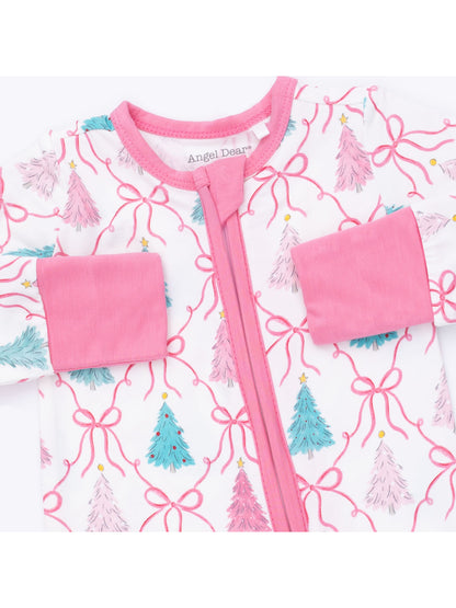 Pink and white children's pajamas featuring colorful Christmas tree patterns and bows.