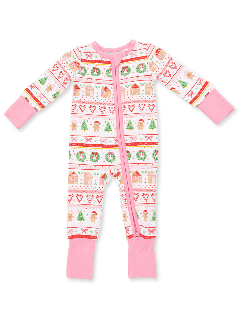 Pink holiday-themed infant pajama, featuring festive patterns of trees, gingerbread, and candy. Suitable for winter.