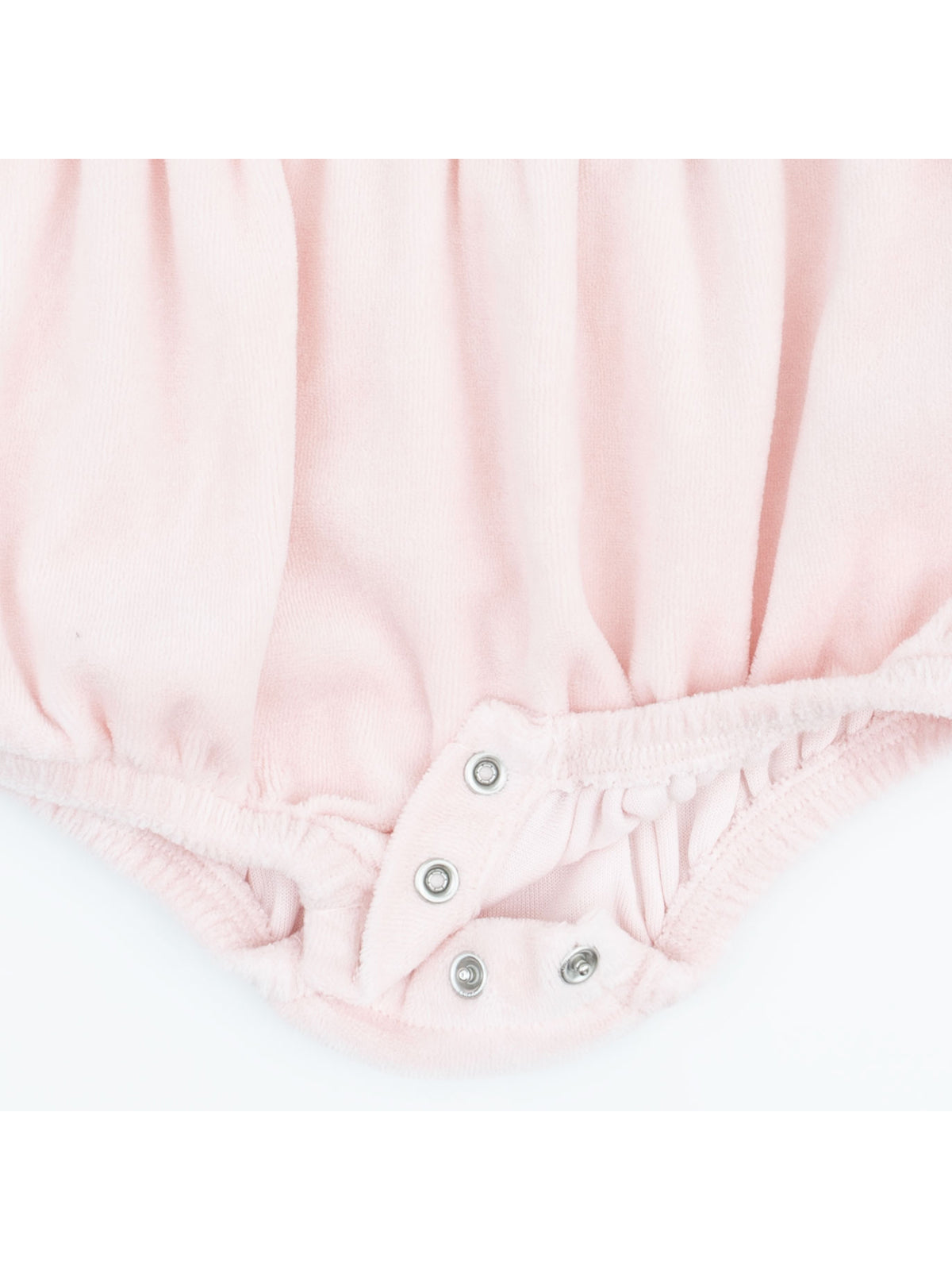 Pink baby onesie bottom with snap closures and gathered fabric details.