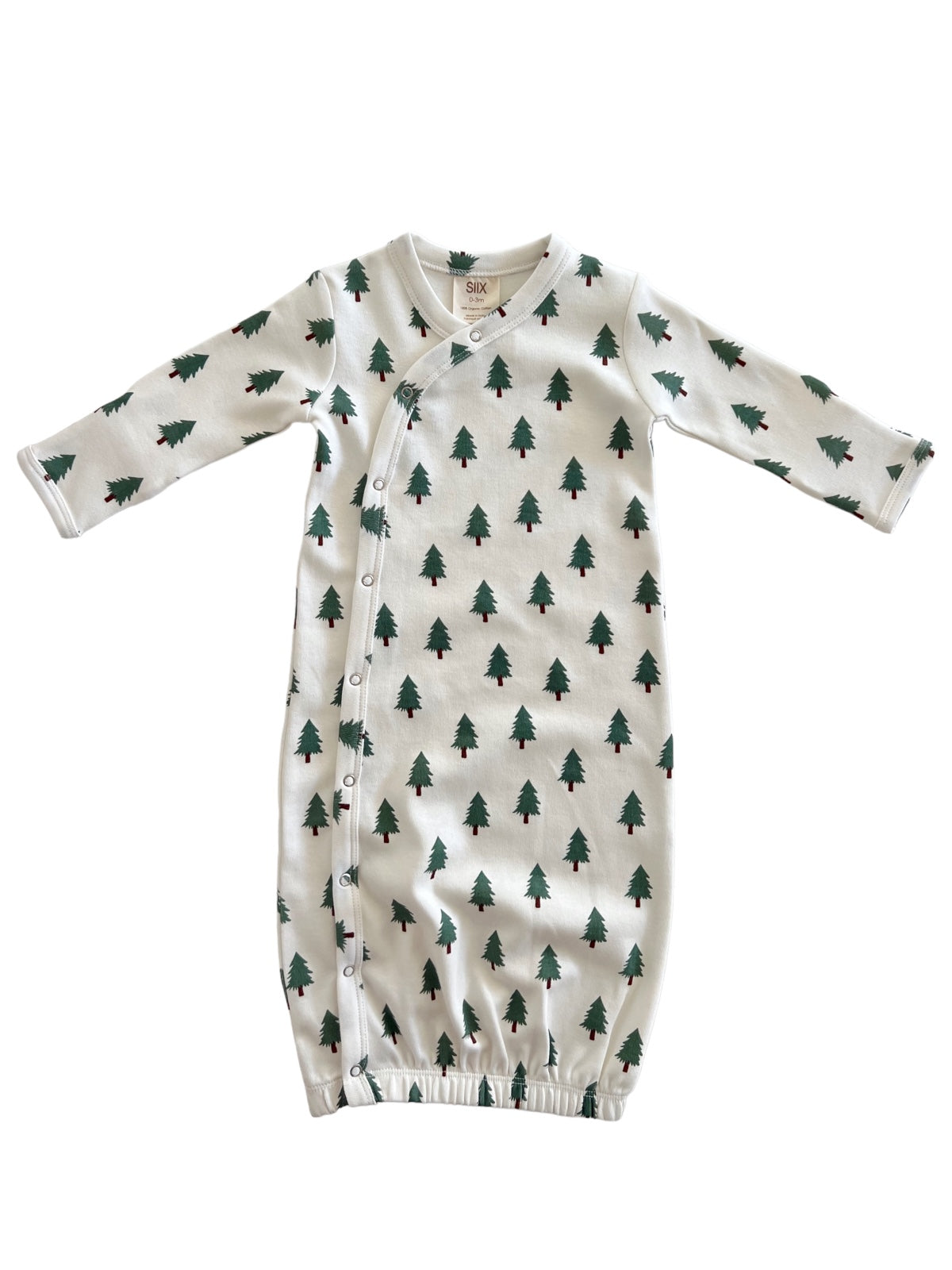 Infant gown with green tree print on white fabric, featuring long sleeves and snap closures.