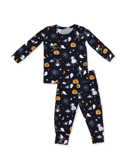 Halloween-themed children's pajama set with ghosts, pumpkins, and skeletons on a dark background.