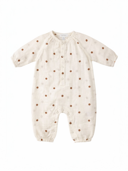 Cream-colored baby romper with brown polka dots and button closure, featuring long sleeves and snap bottom.
