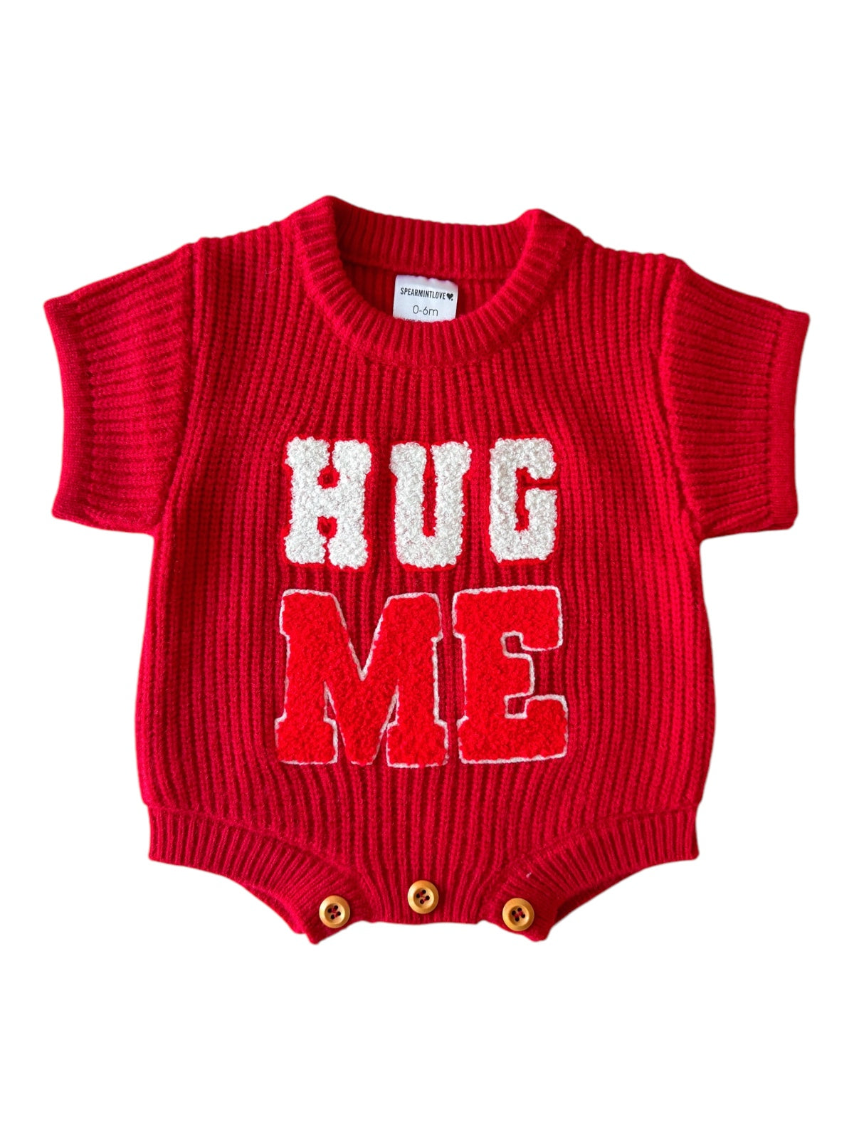 Red knit onesie with "HUG ME" text in white, short sleeves, and three button closure at the bottom.