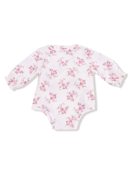 Long-sleeve baby bodysuit with floral pattern on white background and polka dots, featuring a rounded collar.
