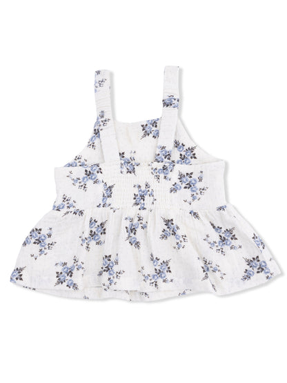 White floral sleeveless top with blue flowers and a flared hem. Ideal for casual summer outfits.