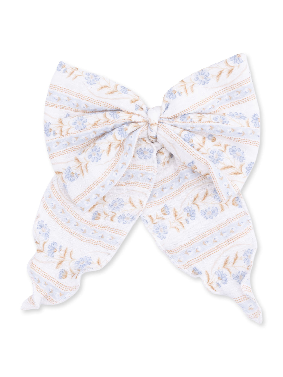 White fabric bow with blue floral patterns and stripes, perfect for hair accessories or decorations.