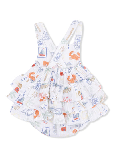 White ruffled dress with colorful sea-themed patterns, featuring crabs, boats, and shells. Perfect for summer.