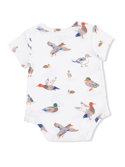 White baby onesie with colorful duck illustrations throughout the fabric.