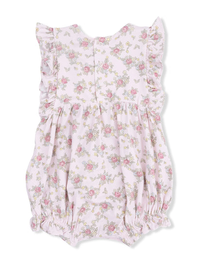 Floral baby romper in soft pink with ruffled shoulders and elasticated bottom, adorned with pink roses and yellow flowers.