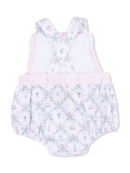 Baby romper with pink accents and patterned design featuring cups, ribbons, and playful motifs.