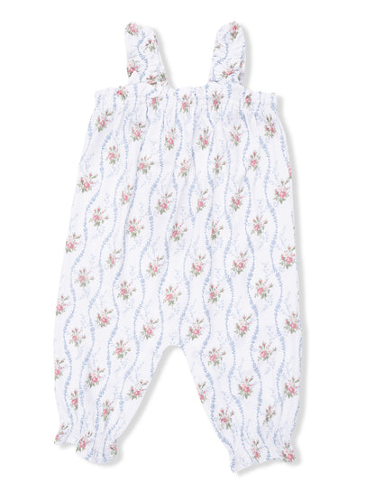 White floral romper with blue and pink flowers, featuring smocked bodice and ruffled straps. Perfect for warm weather.