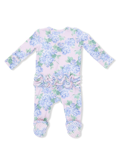 Floral infant romper with long sleeves, ruffled waist, and polka dot footed design, in pastel colors.