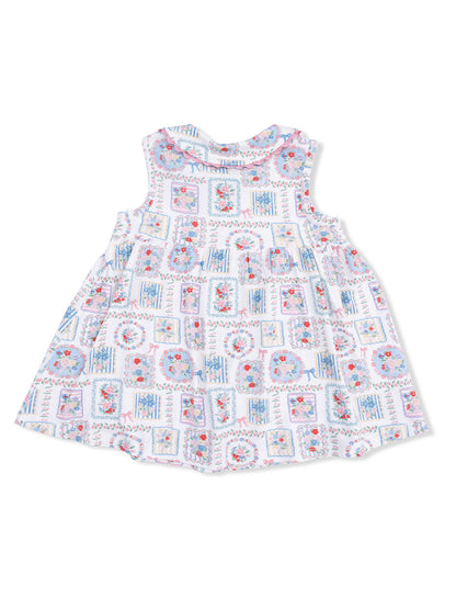 Floral-patterned sleeveless dress with a ruffled neckline, featuring colorful squares and flowers on a white background.