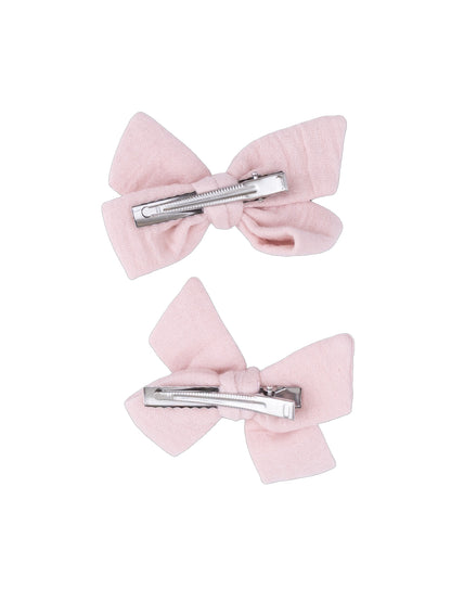 Two pink fabric hair bows with metal clips on a white background.