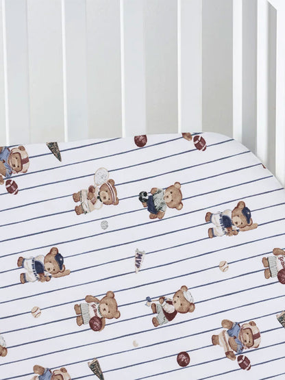 Crib sheet featuring playful teddy bears in sports attire on a blue striped background.