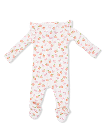 Infant onesie with a fruity peach and bow pattern, featuring long sleeves and footed legs.